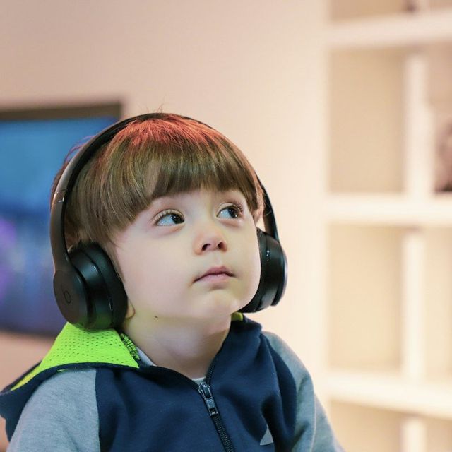 Anak laki-laki memakai headphone menatap ke atas