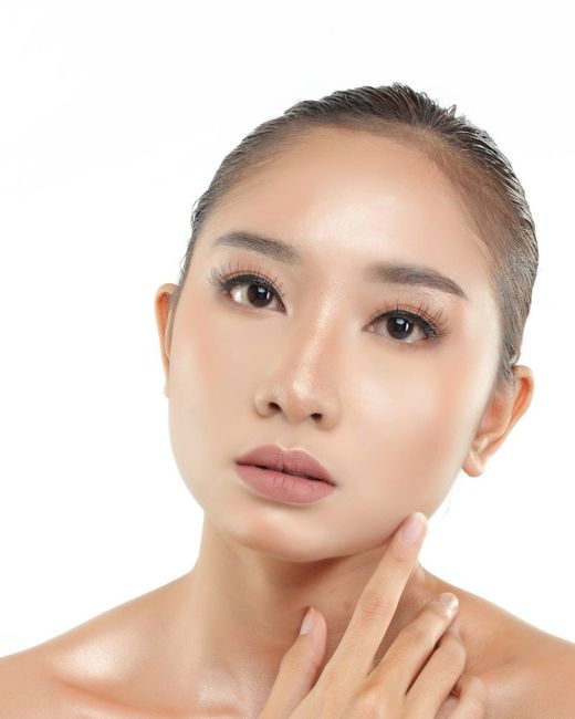 Perempuan dengan kulit lembap menyentuh lehernya