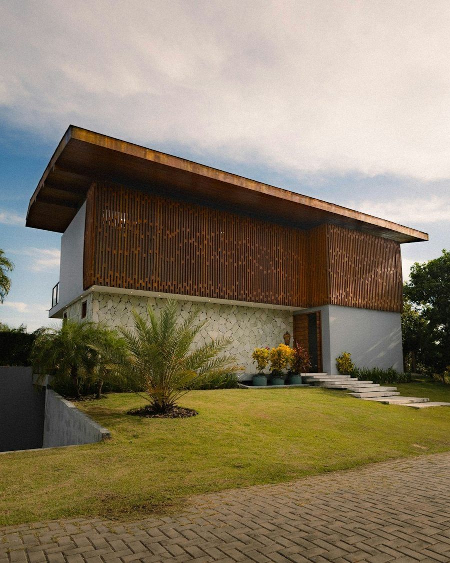 Rumah dengan atap kayu lebar dan halaman rumput