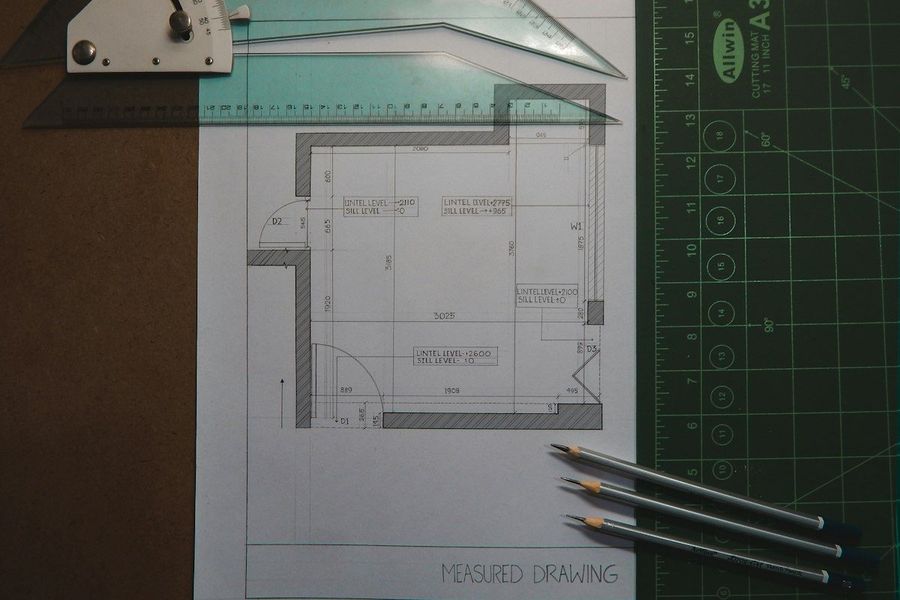Gambar ukur denah dengan pensil di atas meja