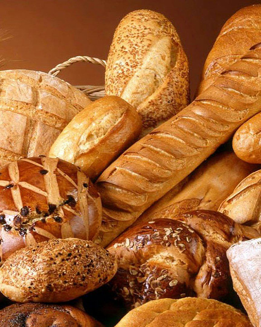 Aneka roti dalam keranjang rotan: baguette, roti bulat, dan croissant