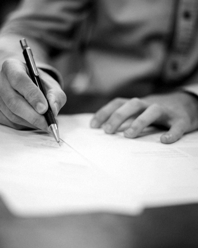Tangan menandatangani dokumen dengan pulpen