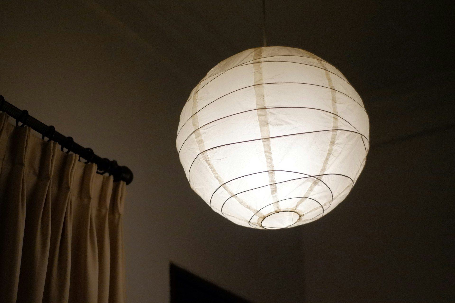 Lampion kertas menyala di ruangan bertirai